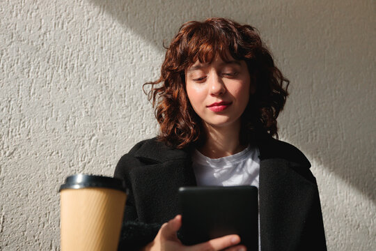 Woman reading e-reader outdoors