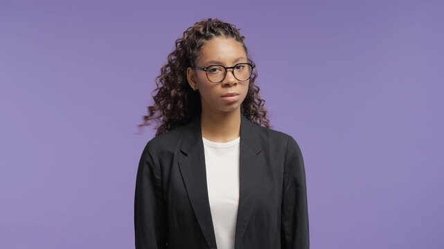 Serious teenage girl disapproving with no head sign, nods head disapprovingly. Denying, Rejecting, Disagree, Portrait of pretty lady on violet background