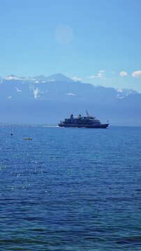Passenger ferry on Lake Geneva with majestic Alps in background