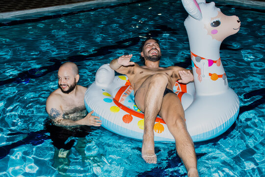 Friends Enjoy Fun Time in Pool With Inflatable llama at Night
