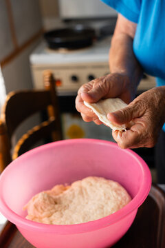 Elderly Woman Stretching Homemade Dough by Hand