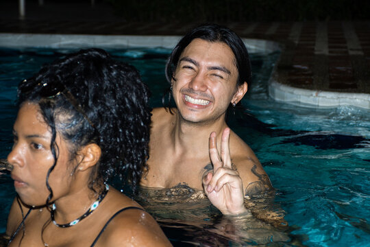 Friends Enjoy a Fun Time in the Pool at Night With Smiles