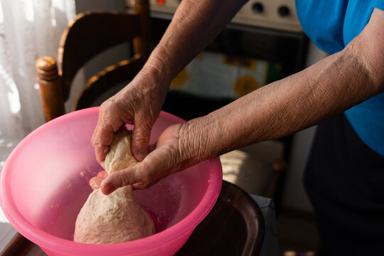 Elderly Woman Stretching Homemade Dough by Hand