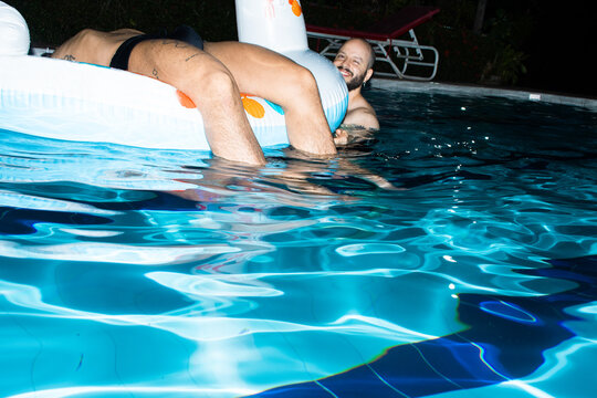 Swimming in a Pool at Night With a Float and Friends