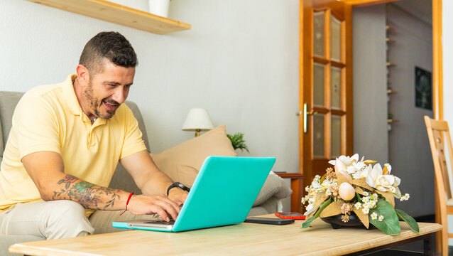 Man working remote from home relaxing on sofa smiling