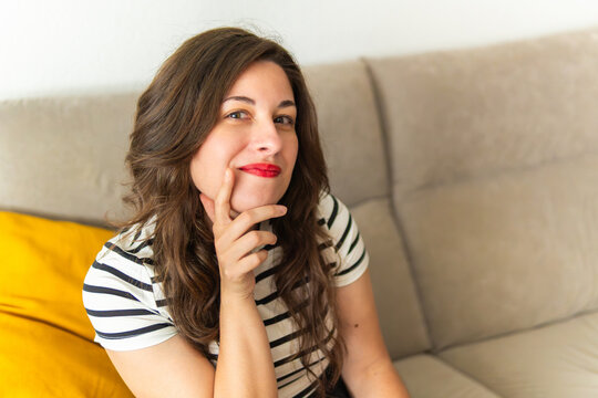 Young woman thinking contemplating planning future on sofa