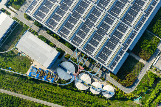 solar rooftop building beside circular industrial tanks
