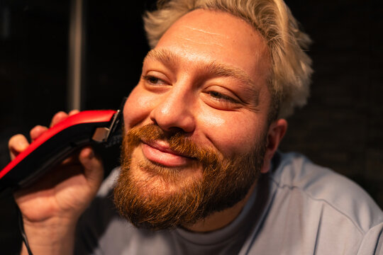 Man Trimming Beard With Electric Clipper