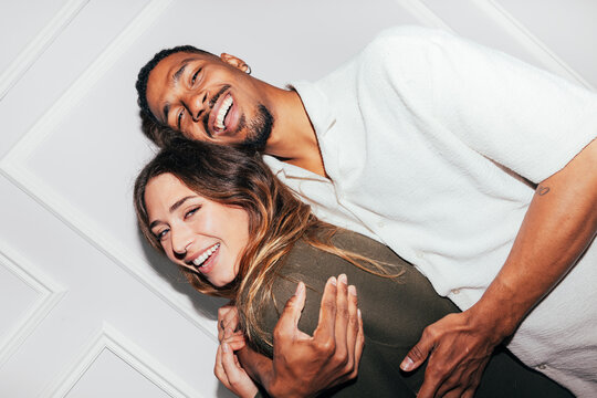 Happy couple laughing together in cozy indoor portrait