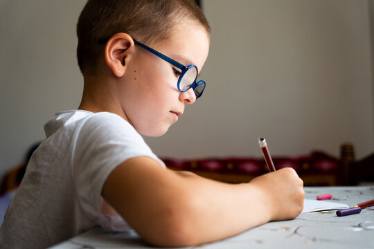 Young Boy Wearing Glasses While Drawing