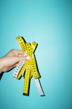Hand holding yellow measure tape with metric and numbers with flashlig