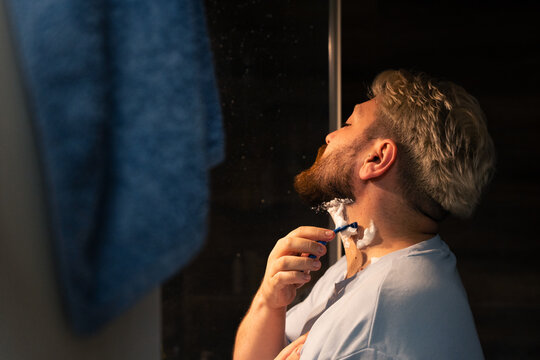 Man Shaving Neck Beard Line In Bathroom Mirror