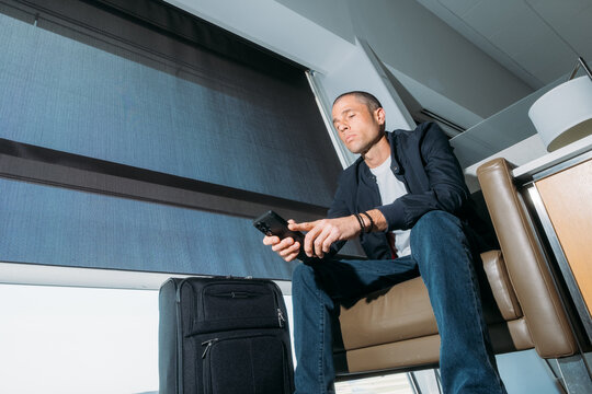 Traveler use phone in airport lounge from low angle