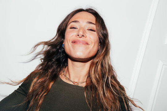 Smiling young woman portrait with long hair and septum ring