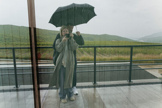 Couple Enjoying Rainy Day Reflections in Serene Landscape