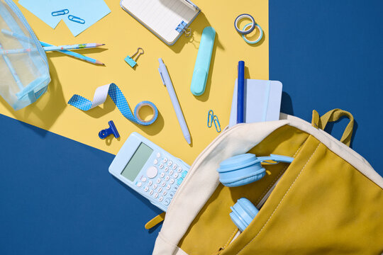 Back-to-school supplies neatly arranged on  on blue table.