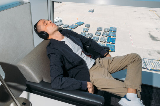Sleeping in airport lounge with headphones