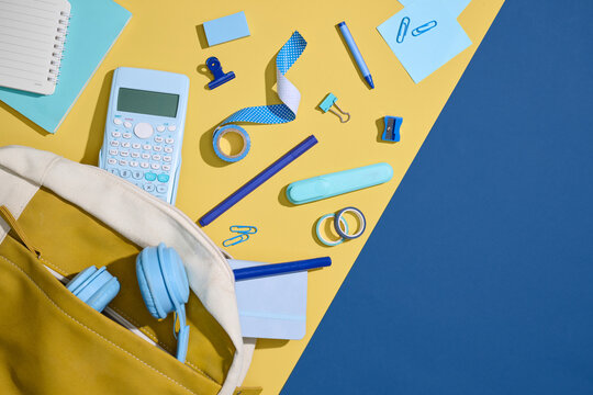 School supplies neatly arranged on a yellow and blue background