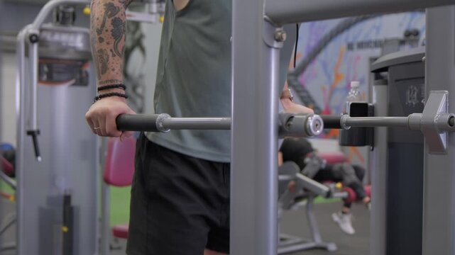 Strength training at the gym using a cable machine in the fitness center during daytime hours