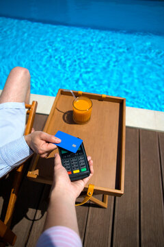 Anonymous man's hand paying with a  credit card via a pos terminal.