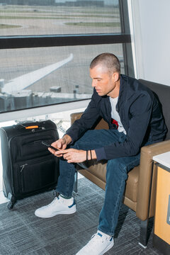 Traveler using phone in airport lounge