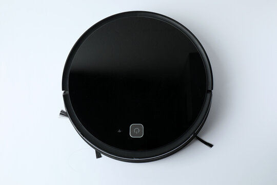 Robotic vacuum cleaner on laminate floor in living room. Smart cleaning technology.