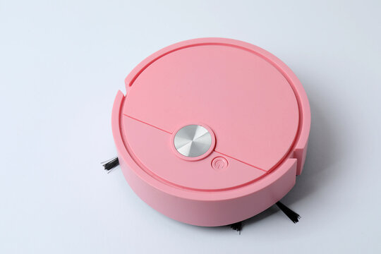 Robotic vacuum cleaner on laminate floor in living room. Smart cleaning technology.