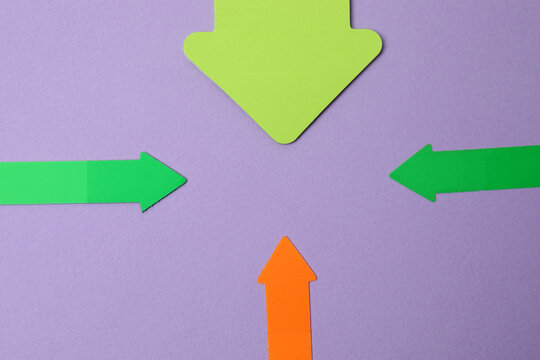 Paper arrow on color background, top view