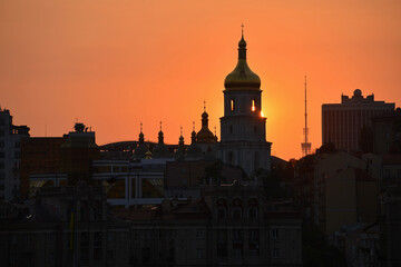 Fototapeta premium Kyiv, Ukraine - August 6, 2026: Summer sunset against the backdrop of St Sophia's Cathedral and the Kyiv TV Tower. The daytime temperature reached 39 degrees Celsius.