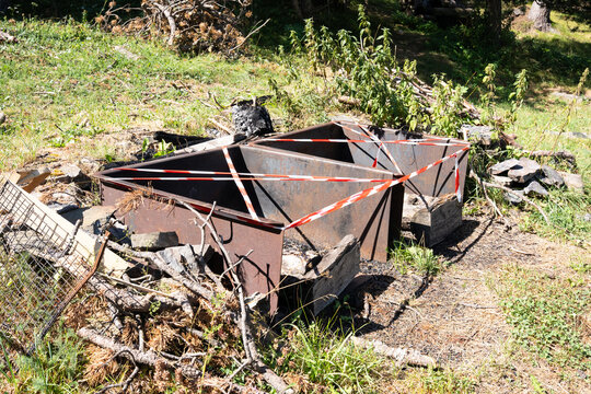 Mountain picnic barbecue grills cordoned off with red and white barrier tape because of seasonal wildfire risk and fire restrictions.