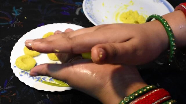 lady hand making laddu for diwali, homemade sweet