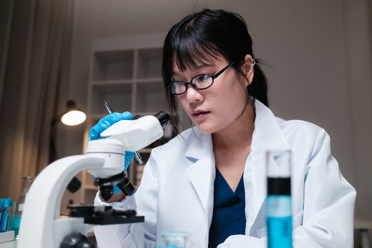 Female scientist working with microscope in laboratory