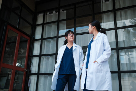 Female doctors discussing work outside hospital building
