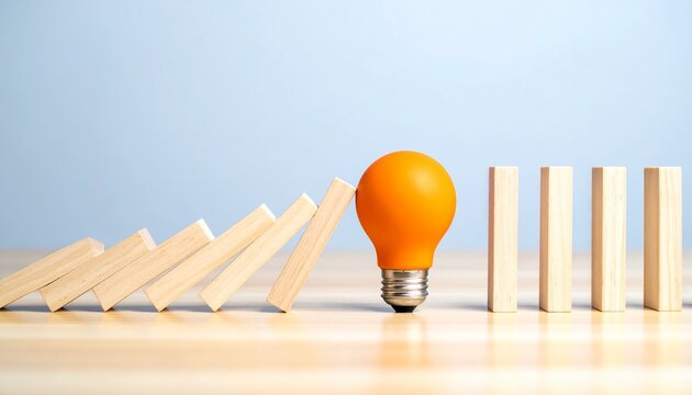 Orange light bulb stopping falling domino blocks chain