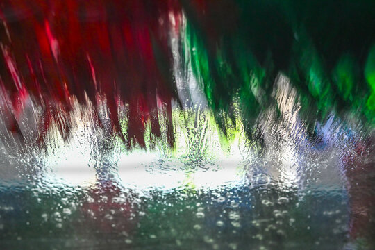 car wash, abstract photo with motion blur, focus on the water on the windshield, background concept for cleaning service and transportation, copy space, selected focus