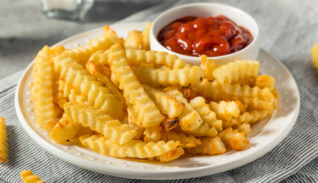 Crispy Crinkle Cut French Fries Served on a White Plate with Tomato Ketchup Dip in High Angle Food Photography