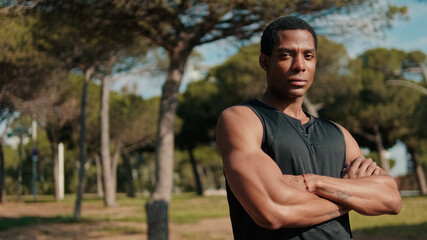 Fototapeta premium Confident Athletic Man In Park With Arms Crossed
