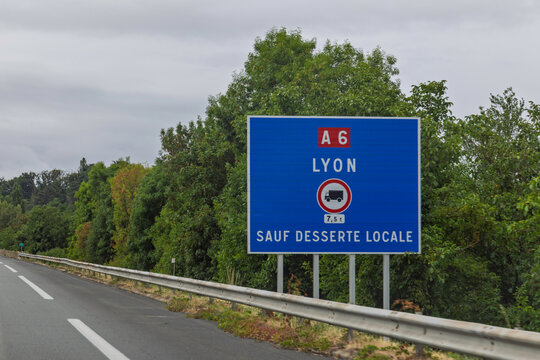 Lyon, France: Large blue highway road sign indicating direction to Lyon on the A6 autoroute with weight limit restrictions.