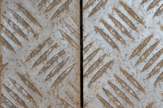 Weathered checker plate metal texture with raised diamond tread pattern