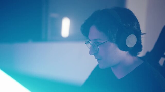 Young Male Gamer Playing Video Games in RGB Neon Gaming Room