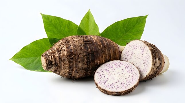 Fresh taro root with green leaves, sliced raw taro corm on white background, organic tropical root vegetable for cooking