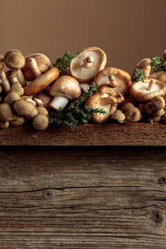 An assortment of mushrooms on a rustic wooden board with sprigs of thyme.