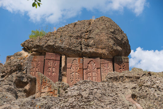 Ancient stone khachkars in rocks of Geghard monastery, historic Armenia landscape with copy space