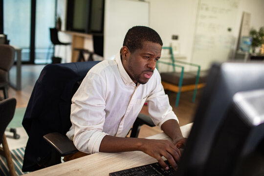 Focused man working on desktop computer in modern office