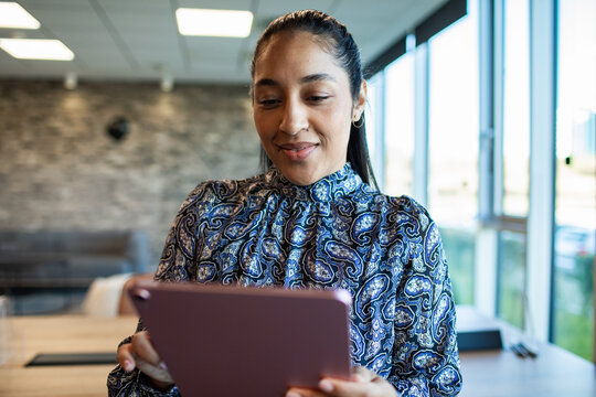 Smiling businesswoman using tablet in modern office