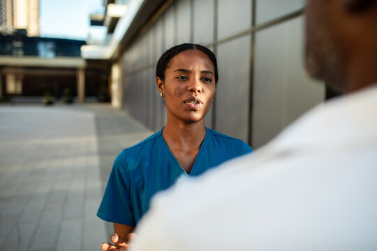 Healthcare worker talking with patient outside hospital