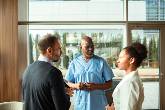 Medical team and administrator discussing patient care in hospital lobby
