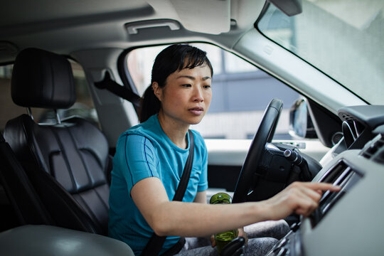 Woman driver using car touchscreen inside suv