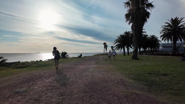 Waterfront walk past palm trees at sunset, Parque Rodo, Montevideo, Uruguay