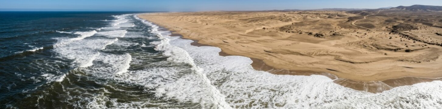 Panoramic Aerial View of Ocean Waves Meeting Desert Sand Dunes